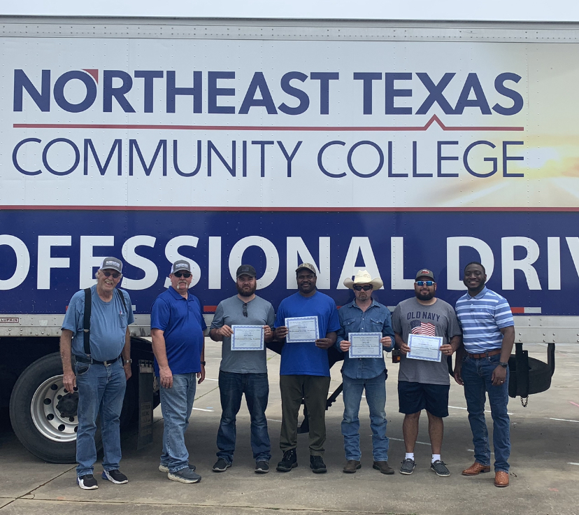 truck driving graduates in front of truck