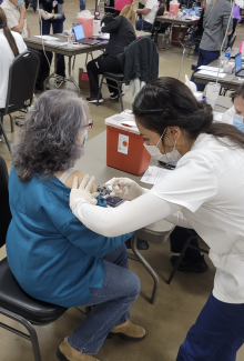 student giving vaccine shot