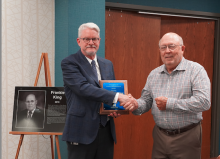 Frankie King receiving plaque from Dr. Clinton