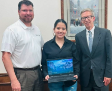 cypress bank vp presenting laptop to student